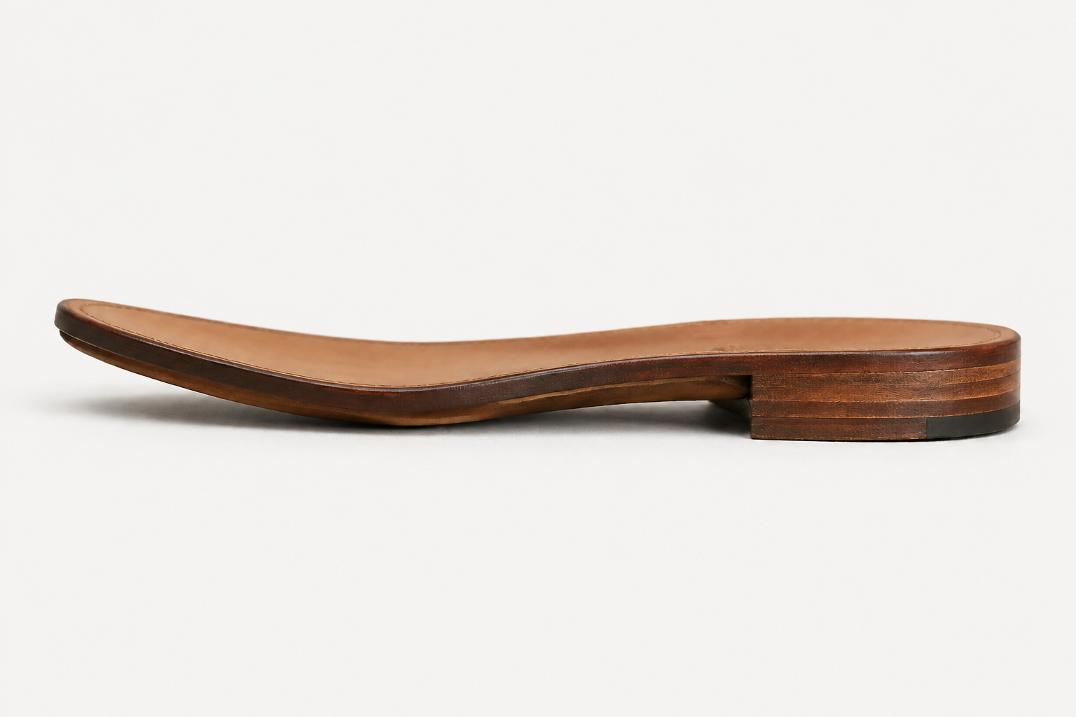 Side profile of a leather sole concept with stacked heel and burnished edge